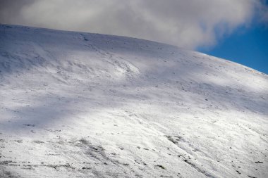 Galler dağ kışı manzarası. Storey Arms 'ın üstündeki dağların tepesinde Brecon Beacons' da kar yağıyor. Buzlu koşullar ama güneş parlıyor ve tepelerdeki karları eritti..