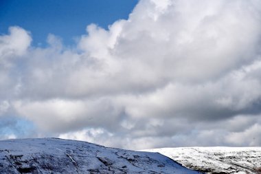 Galler dağ kışı manzarası. Storey Arms 'ın üstündeki dağların tepesinde Brecon Beacons' da kar yağıyor. Buzlu koşullar ama güneş parlıyor ve tepelerdeki karları eritti..