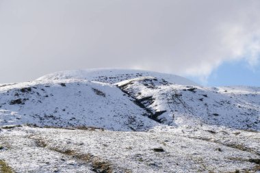 Galler dağ kışı manzarası. Storey Arms 'ın üstündeki dağların tepesinde Brecon Beacons' da kar yağıyor. Buzlu koşullar ama güneş parlıyor ve tepelerdeki karları eritti..