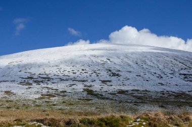 Galler dağ kışı manzarası. Storey Arms 'ın üstündeki dağların tepesinde Brecon Beacons' da kar yağıyor. Buzlu koşullar ama güneş parlıyor ve tepelerdeki karları eritti..