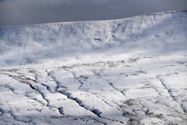 Galler dağ kışı manzarası. Storey Arms 'ın üstündeki dağların tepesinde Brecon Beacons' da kar yağıyor. Buzlu koşullar ama güneş parlıyor ve tepelerdeki karları eritti..