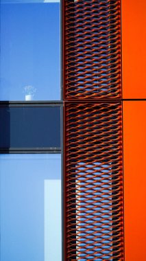 Cardiff Wales October 29 2023: Impactful, contemporary multi storey offices with vibrant orange rectangular panels interspersed with glass that reflect the ever changing sky above. clipart