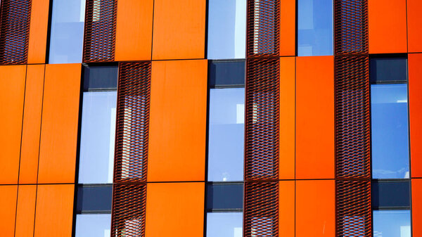 Кардифф Уэльс 29 октября 2023 года: Влиятельные современные многоэтажные офисы с ярко-оранжевыми прямоугольными панелями, смешанными со стеклом, отражающими постоянно меняющееся небо над головой.