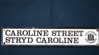 Cardiff, Galler 29 Ekim 2023, Caroline Sokağı tabelası kırmızı tuğlada. Chippy Lane olarak da bilinir, Chip Alley. Bir paket cips, köri ve diğer hazır yiyecekler için gece yarısı mekanı olarak meşhurdur..  