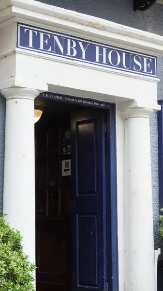 stock image Tenby House with its name in blue above white pillars and cornices, was built in 1821 by Sir Williams Paxton on the site of the Globe Inn. 