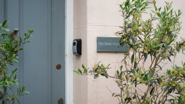 Tenby, Pembrokeshire, Galler - 02 Temmuz 2024: Eski bir fırın evi şimdi şehir merkezinde plaket ve gri kapılı bir yerleşim yeri.