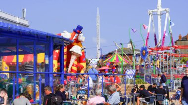 Barry Island, Vale of Glam, Wales, Aug 30 2024: The promenade fun park with its small children's rides is vibrant and busy. BBC Gavin and Stacey film crew started filming around that area on Sept 1st. clipart