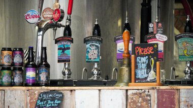 Tenby, Pembrokeshire, Wales July 03 2024: A selection of bottled, canned and draught craft beer on sale at the Tenby brewery established in 2015 in Sergeants Lane. A popular place for tourists. clipart