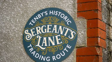 Wall plaque on a stone an brick wall in Tenby naming Tenby's historic Sergeants Lane, and important trading route from the harbour to the town centre. clipart