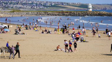 Porthcawl, Bridgend, Wales: Aug 15 2024: Coney Beach, Porthcawl is one of the few seaside resorts in South Wales where children of all ages can enjoy a traditional donkey ride across the sand. clipart