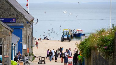 Tenby, Pembrokeshire, Wales - July 03 2024: Boat trips to Caldey Island leave Castle Beach in Tenby everyday.  The long slipway makes the beach very accessible, safe and sheltered cove for visitors .  clipart