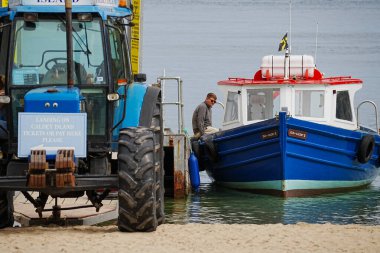 Tenby, Pembrokeshire, Wales - July 03 2024: Boat trips to Caldey Island leave Castle Beach in Tenby everyday.  The long slipway makes the beach very accessible, safe and sheltered cove for visitors .  clipart