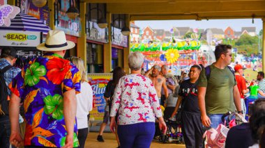 Barry Island, Vale of Glam, Wales, Aug 27 2024: A sunny summer bank holiday, guaranteed to draw the crowds for beach time, ice-cream, fish and chips, souvenir shopping and fun in amusement arcades.    clipart