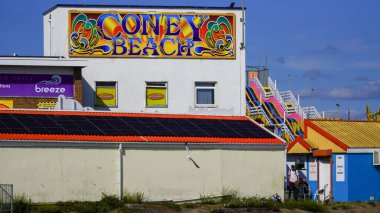 Porthcawl, Bridgend, Wales Aug 15 2024: Looking over to Coney Beach entrance and fairground rides. An iconic view which will be demolished in the next few years making way for new luxury apartments. clipart