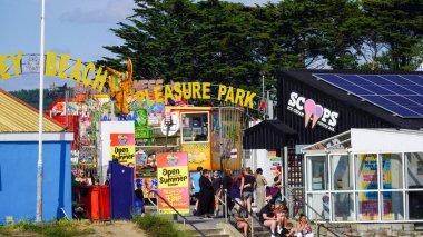 Porthcawl, Bridgend, Wales Aug 15 2024: Looking over to Coney Beach entrance and fairground rides. An iconic view which will be demolished in the next few years making way for new luxury apartments. clipart