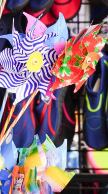 Parlak renkli plaj topları, rüzgar değirmenleri ve diğer oyuncaklar satışta ve Galler 'deki geleneksel bir İngiliz sahil beldesi olan Barry Adası' ndaki mağazaların önünde sergileniyor.