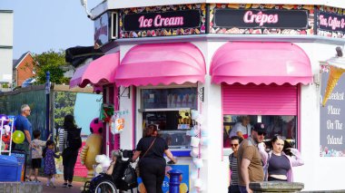 Barry Adası, Glamorgan, Galler Vadisi - 29 Ağustos 2024: Parlak renkli pembe ve beyaz bir dondurma salonu, büfesi, Barry Adası 'ndaki gezinti alanında, Gavin ve Stacey' nin evi. Ziyaretçiler arasında popüler