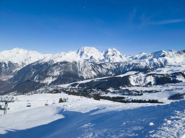 Fransız Alpleri 'ndeki Courchevel kayak alanının en üst manzarası. Karlı yamaçlar, çam ağaçları, sandalyeler... .