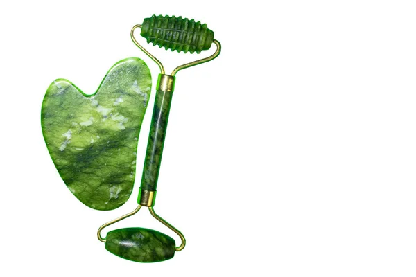 Yeşil yüz silindiri ve gua sha taşı beyaz arkaplanda izole edilmiş