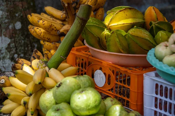 local Balinese fruits like small bananas and star fruit on a market