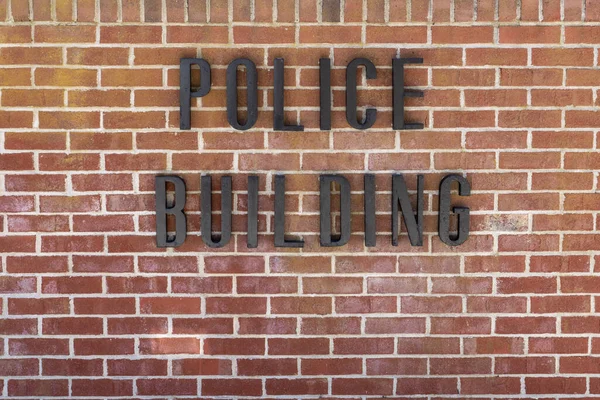 stock image Police Building black letters on a red brick wall