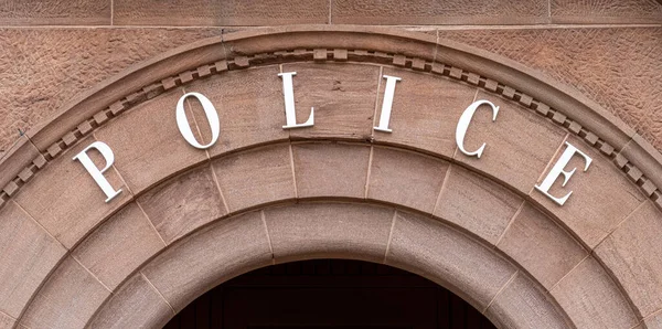 Stock image the word POLICE on a brownstone archway