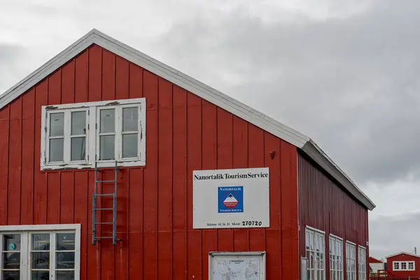 stock image Nanortalik, Greenland - Aug. 24, 2023: The Nanortalik Tourism Service building offers restrooms, information, and souvenirs in a red painted building, which is traditional for stores in Greenland.