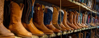 Seçici odaklı bir dükkanda birçok kovboy çizmesinin panoramik görüntüsü