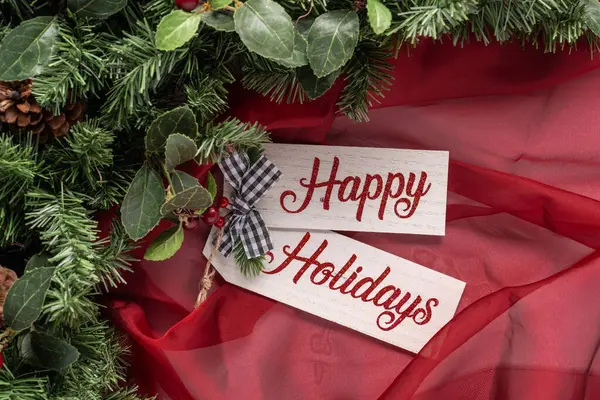 Saf kırmızı kumaş, yeşillik ve küçük siyah beyaz pamuklu yay ile tahta tahtada mutlu tatiller.