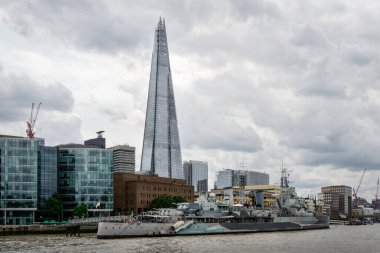 Londra, İngiltere - 24 Temmuz 2024: Londra Thames limanı, HMS Belfast manzaralı, Kraliyet Donanması savaş gemisi şimdi İmparatorluk Savaş Müzesi 'nin bir parçası ve piramit şeklinde bir gökdelen olan Çömlek.
