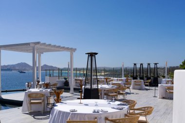 Cabo San Lucas, B.C.S., Meksika - 15 Mart 2025: Günbatımı Monalisa Akdeniz restoranı Cabo Körfezi 'ne bakan açık hava yemekleri.