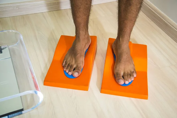 Close-up of male feet standing on foot treatment apparatus