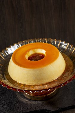 Karamelli kremalı muhallebi koyu ahşap bir arka planda..