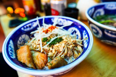 Bun Bo Nam Bo, Thien Ly Restoranı Da Nang, Vietnam. Kızarmış etle kurutulmuş şehriye, içinde sitronella, biber, soğan, fıstık, şifalı otlar ve kızarmış et bulunan bir kase pirinç eriştesidir.. 