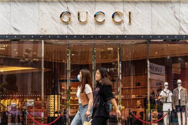 Chongqing, Çin - 08 Mayıs 2024: Jiefangbei 'deki Gucci mağazasının önünden geçen müşteriler.
