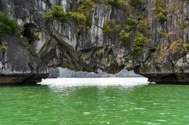 Hollow under Saddle Islet aka Hon Yen Ngua in Ha Long Bay, Quang Ninh, Vietnam. clipart