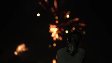 2024 Bölge Günü 'nde Darwin, Mindil Plajı' nda havai fişeklerin keyfini çıkaran genç Asyalı kadın..