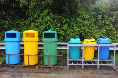 Renkli plastik geri dönüşüm kutuları çöp kutularını çöp ayrıştırma, farklı çöp geri dönüşüm türlerinin toplanması ve Tayland 'daki Tropikal yağmur ormanlarında ayrı atık toplama