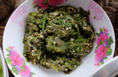 Kuzey Tayland 'ın yeşil biberleri Kantoke' da beyaz kaseye batırılmış, Tayland 'ın ahşap çatal bıçaklarından.