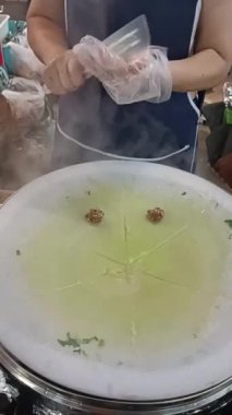 Asyalı kadın aşçı Tayland 'da Tayland usulü domuz etli börek pişiriyor.