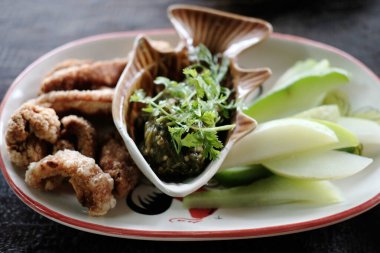 Domuz derisi, domuz eti tırmığı, Nam Prik Num ile domuz eti çatırtısı ya da beyaz tabak ve bitkisel sebzeye Kuzey Thaig Green biberi sosu. Tayland yemeği.