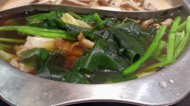 Sebzeli ve etli sıcak tencerede shabu ya da sukiyaki haşlamak. Asya yemekleri.