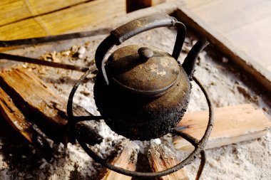 Eski, kirli çaydanlık, odun ocağı ve kamp yapmak için kömür sobası.