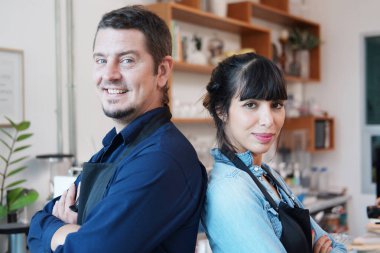 Gülümseyen Kafkas barista çifti aşk ortaklığı önlük portresi takıyor. Küçük bir kafe ve kahve dükkanı açacağız. 