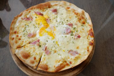  Tahta tabakta taze ev yapımı jambon peynirli pizza.