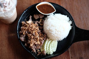 Fried chicken with garlic and pepper with sauce and rice on black plate. Cuisine of Thai food in Thailand clipart