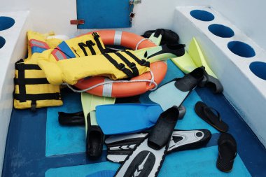 Denizdeki sürat teknesinde lastik halkalar ve can yelekleriyle dalış ekipmanları.