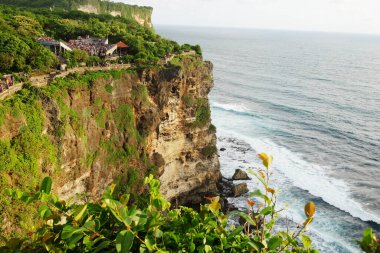 Bali, Endonezya - 10 Aralık 2018: Suluban sahilindeki Pura Luhur Uluwatu tapınağının altında kayalık kıyı ve okyanus dalgaları olan sahil uçurumu veya Bali 'deki mavi nokta