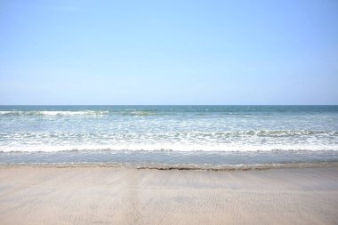 Yatay sakin deniz manzarası. Kumsalda dalgalar, bulutlar ve açık havada mavi gökyüzü. Endonezya 'nın Bali şehrinde yaz tatili