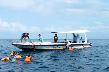 Bali, Endonezya - 07 Aralık 2018: Sürat teknesiyle Nusa Penida denizinde şnorkelle yüzmeye giden turistler. Balıkçı taşımacılığı